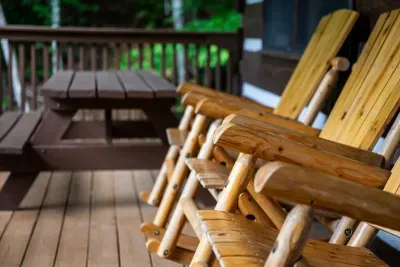 Pull up to the picnic table or settle into a handcrafted log rocker — outdoor meals and lazy afternoons both happen right here, woods as your backdrop. Dinner always tastes better