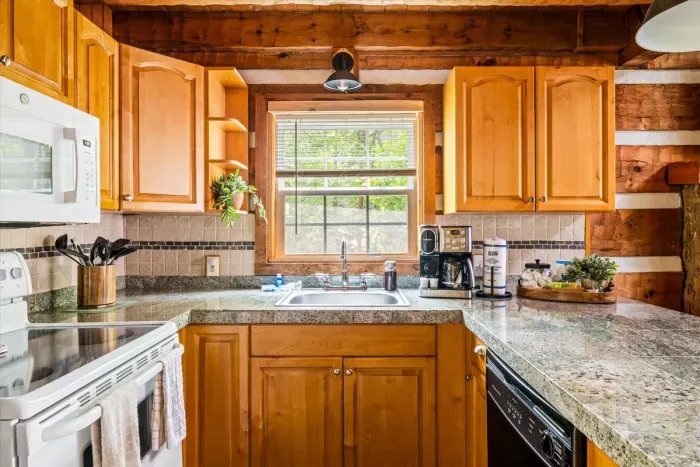 A fully stocked mountain kitchen — granite island, full appliance suite, and that window view making every meal feel like it belongs in a mountain cookbook.