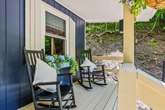 Covered front porch with rocking chairs that get used every single stay. Coffee at sunrise, something stronger at dusk, and rain on the tin roof if you're lucky.