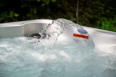 Jets on, water churning, steam climbing into the trees. The hot tub is drained and refreshed between stays — step in and let it do the work on your shoulders.