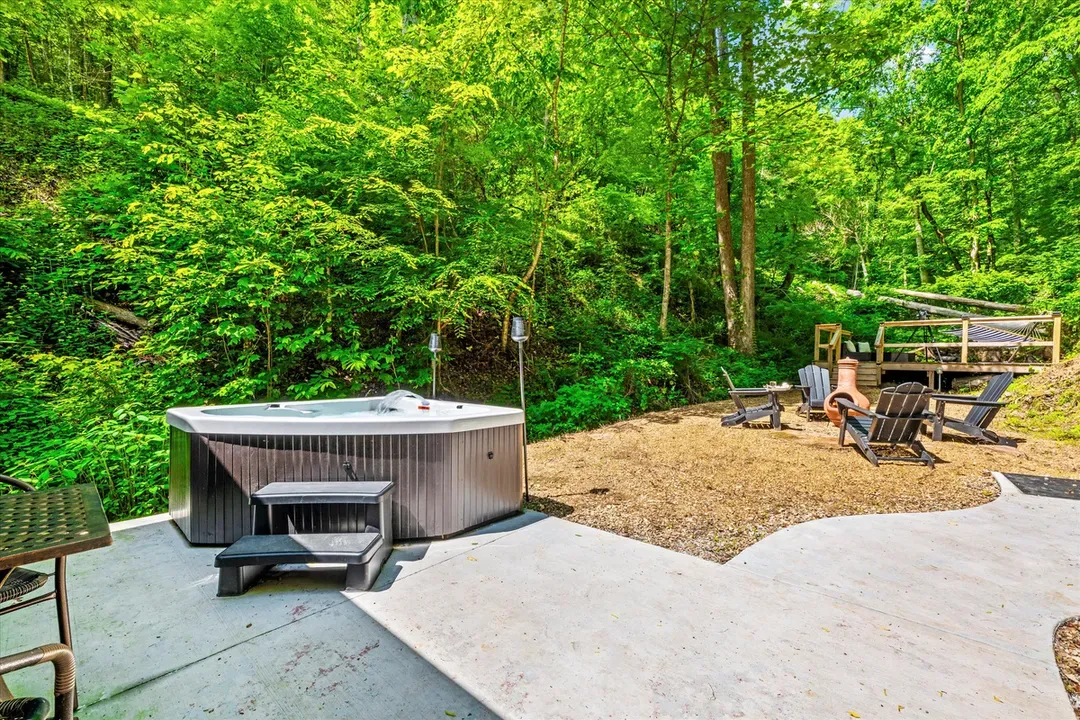 Private hot tub steps from the fire circle — soak, then move to the chairs when the flames catch. The whole backyard is yours, and the trees keep it that way.