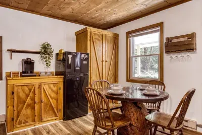 Full kitchen in warm pine with a dining table for four right beside it. Cook what you picked up in town, reheat, or go all out — either way, you'll eat together.