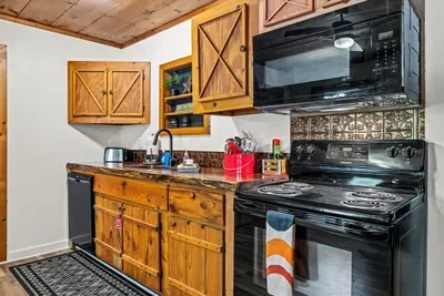 Full-size range, oven, microwave, and dishwasher — a small cabin that cooks like a real house. Roast a chicken, bake the cobbler, do it all up here.