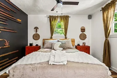 Fresh towels stacked on a made bed, slat wall behind, window on the woods. We set the room up like family's coming, because that's how the whole place is run.