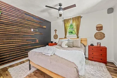 Bedroom with a window on the trees and a slat wall you'll want to photograph. Fresh linens, quiet so deep it's almost loud, and the best sleep of the trip.