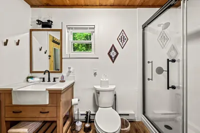 Full bath with a walk-in glass shower, vessel sink vanity, and a window that lets the morning in. Rinse the trail off and start the evening over.