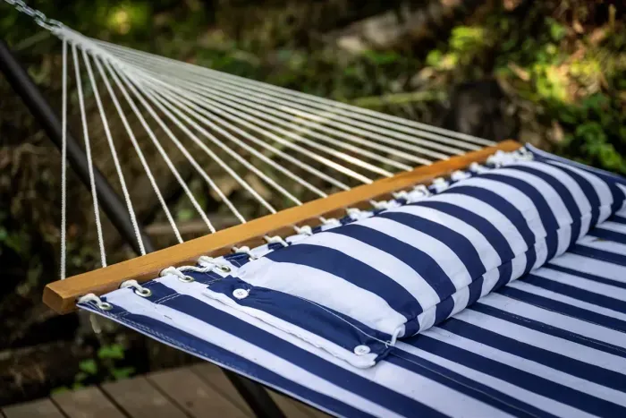 The hammock nobody gets out of. Strung on the deck with the forest doing its thing overhead — bring a book, but don't expect to finish a chapter.