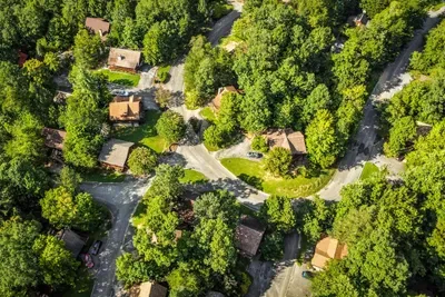 A quiet mountain community of cabins tucked along winding wooded lanes — peaceful and private, with paved road access running right up to the front door.
