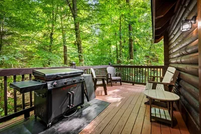 Fire up the flat-top griddle on the covered deck — smash burgers at dusk, pancakes at sunrise, rocking chairs waiting a few feet away. Dinner tastes better in the trees.