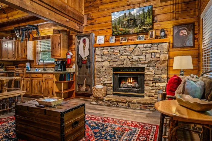 The fireplace is already crackling. Stone hearth, plaid pillows, and a sofa deep enough to disappear into — guests say this is where the whole trip finally slows down.