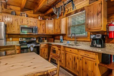 Granite counters, stainless appliances, cast iron hanging overhead, and a coffee station that's ready before you are. This kitchen was built for cabin breakfasts and slow refills.
