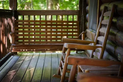 Rocking chairs on the shaded deck behind a lattice screen — private, breezy, and built for that unhurried hour between the trailhead and whatever's going on the griddle.
