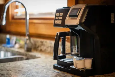 Drip coffee maker, mugs, and filters set out on granite — the first thing that happens every morning here, well before anyone mentions boots or hiking plans.