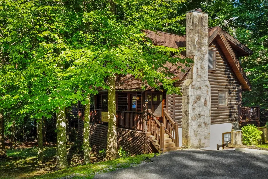 Tucked under a canopy of hardwoods, this log cabin greets you with a stacked-stone chimney and a driveway that ends where the quiet begins. Park once, unplug for days.