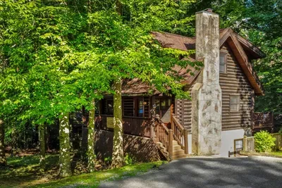 Tucked under a canopy of hardwoods, this log cabin greets you with a stacked-stone chimney and a driveway that ends where the quiet begins. Park once, unplug for days.