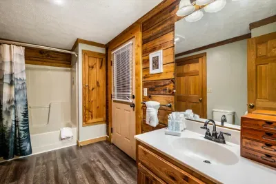 A full bath with tub-and-shower combo, wide vanity, and warm pine walls — rinse off the trail dust, hang your towel, and let the rest of the evening take its time.