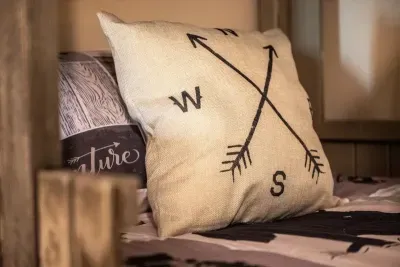 Follow your adventure north, south, east, or west ➡️ – cozy cabin bedroom with nature-themed décor.