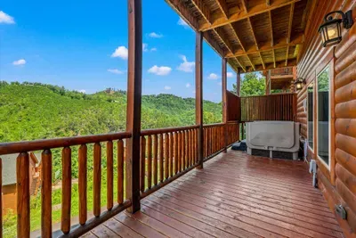 Covered deck with rockers and the hot tub at the end