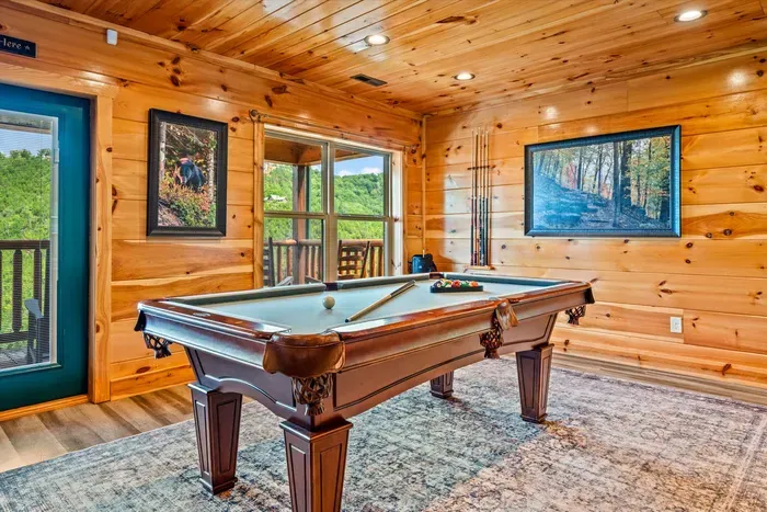 Pool table with the windows and the woods behind it