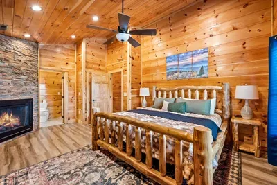 Log bed frame with a fireplace at the foot of it
