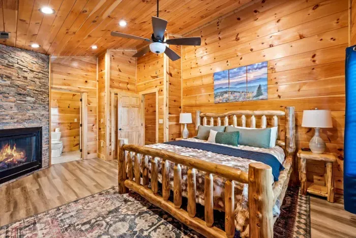 Log bed frame with a fireplace at the foot of it