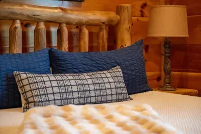 Plaid and denim pillows on a made-up bed