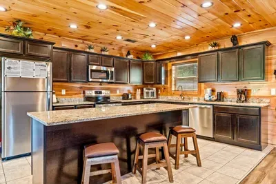 Stainless appliances and a granite island with stools