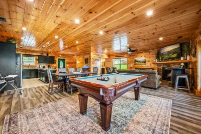 Pool table, kitchen, and living all under vaulted pine