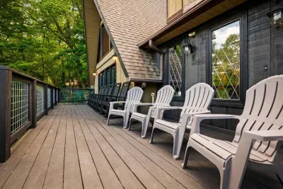 Wraparound deck lined with Adirondack chairs and forest as far as you can see. Morning coffee, evening wine, the trees keeping you company either way.