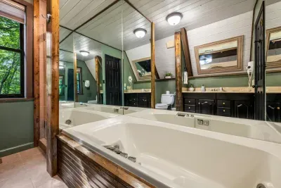 Deep soaking tub tucked into a forest-green ensuite — draw a bath, dim the lights, and let the day melt off. Guests' favorite way to unwind after time on the trails.