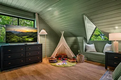 A whole room just for the kids — reading teepee, play nook, and a comfy bed under the eaves. The detail that turns "a cabin" into "the one the kids beg to go back to."