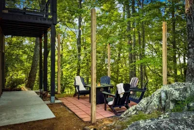 Fire pit set into a natural stone patio, tucked among the trees and mossy boulders. Late nights out here are where the trip's best stories start.