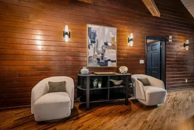 Tucked-away sitting nook wrapped in warm wood paneling — two swivel chairs and quiet corners made for morning coffee or the good book you finally finish up here.
