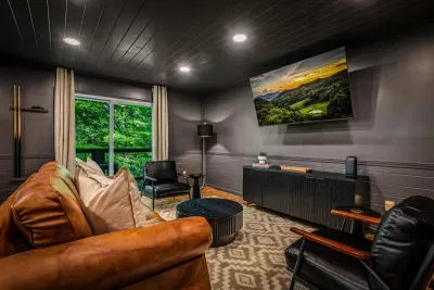 Moody media lounge with a big-screen TV and leather seating built for movie marathons. Dim the lights, cue the film, and let the mountain night roll on.