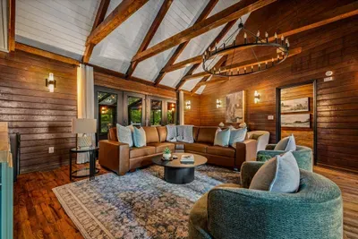 Soaring wood-beam ceilings, a wrought-iron chandelier, and deep leather seating built for slow mornings and long conversations. Sink in — this great room is the crowd favorite.