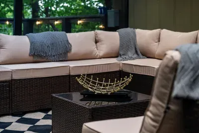 Deep cushions, soft throws, and a spot for everyone — outdoor lounging built for slow conversation as the light fades through the trees.