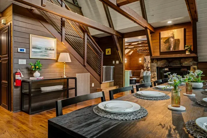 Handcrafted dining table for the whole party, tucked beside warm wood paneling and the stone fireplace. Pull up a chair — this is where the trip's best conversations happen.