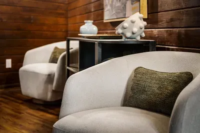Quiet sitting corner with plush swivel chairs and warm wood walls — a soft spot to steal ten minutes with a book. Comfort tucked into every room.