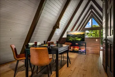 Tucked-under-the-eaves nook with a game already set out and forest filling the window. Pull up a chair for a round before dinner — this corner earns its keep.