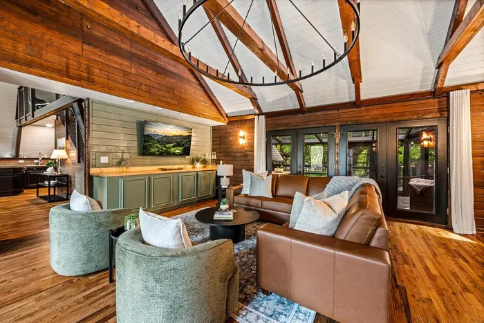 Great room flows right into the wet bar — pour a drink, claim a couch, and settle in under the wrought-iron chandelier. Open-concept living built for easy nights in with the crew.