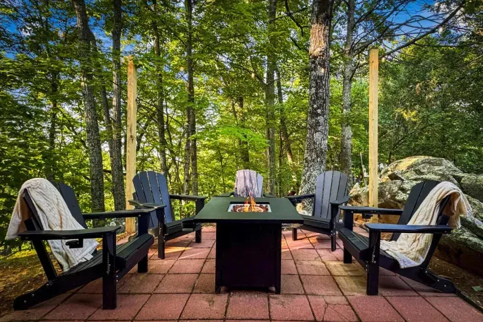 Gather 'round the gas fire pit as dusk settles through the trees — Adirondack chairs, warm blankets, and the easy conversation that runs late. The heart of every trip up here.