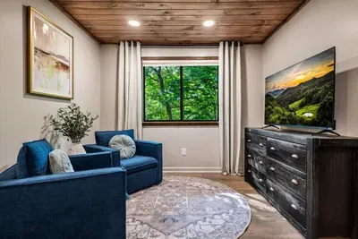 Private bedroom retreat with its own sofa, smart TV, and a window full of green. Room to spread out, a movie within reach, and the trees right there when you wake.