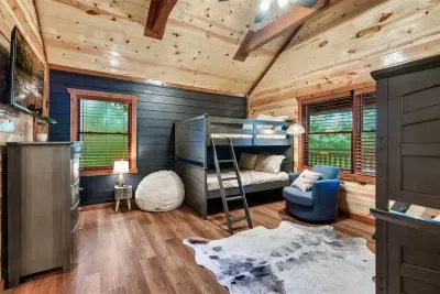 Bunk room with blue accent chair, bean bag, and hardwood floors — a full hangout space, not just a place to sleep. Your younger guests will live in here.
