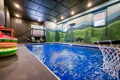 Watermelon floats, a poolside basketball hoop, and a Smoky Mountain mural overhead — this is the indoor pool that makes kids beg to come back next year.