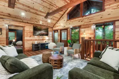 Open-concept living room with soaring wood ceilings and floor-level views into the treetops — the kind of space where everyone naturally gravitates together.