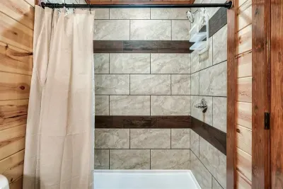 Floor-to-ceiling tile walk-in shower — rinse off the mountain, warm up, and feel human again. Spa-level finishes that earn their place in a cabin this good.