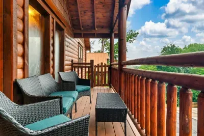 Private deck off the cabin with wicker loungers, open sky, and nothing but treetops ahead — your personal exhale spot between adventures.