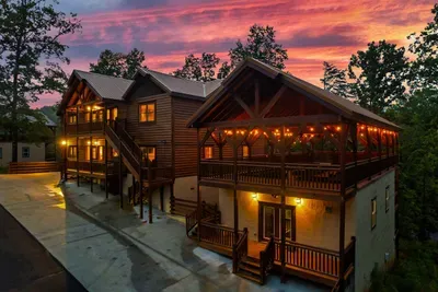 String lights spilling across the covered deck against a purple mountain dusk — pull up, step out of the car, and feel the trip shift into something different the moment you arrive.