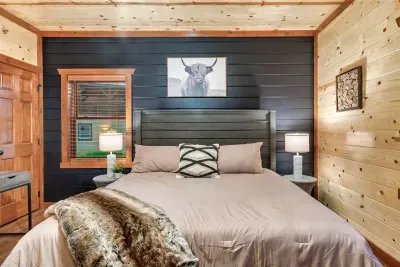 Sink into this king with a fur-draped headboard and highland cow art watching over you — rugged cabin soul wrapped in layers of warmth and texture.