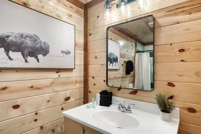 Knotty pine bathroom with a bison print above the vanity — even getting ready feels like part of the mountain experience. Clean, character-rich, and ready for your crew.